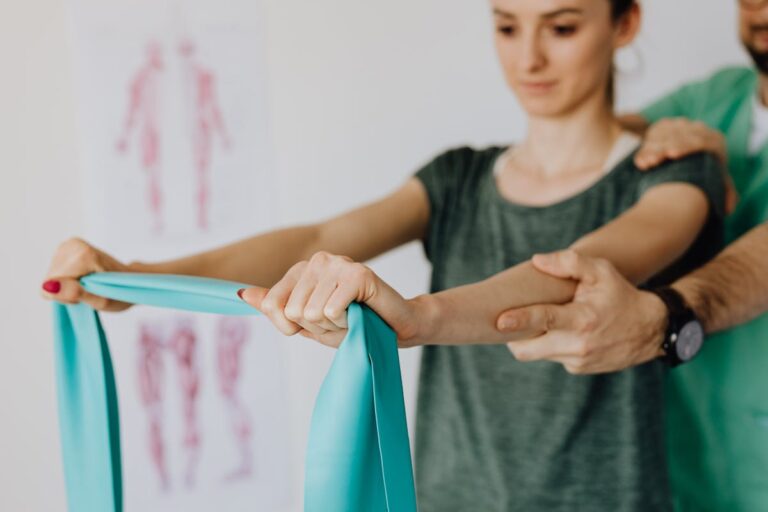 Crop unrecognizable chiropractor and female patient with elastic tape