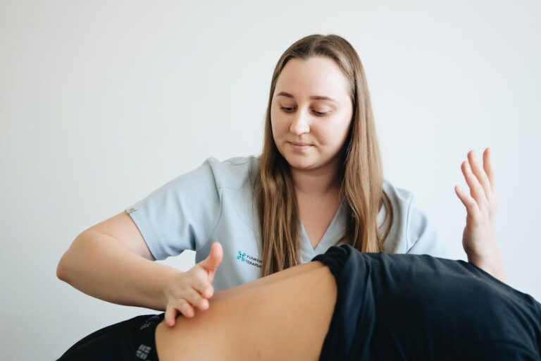 Physiotherapist Massaging Back of Patient